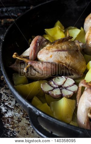 roasted quail with potato wedges and garlic