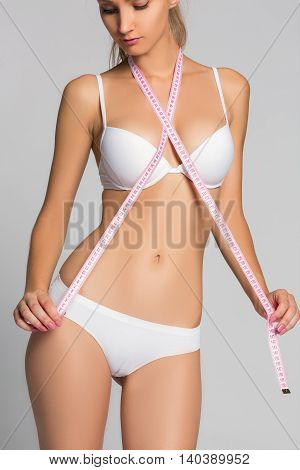 Sporty woman measuring up her chest isolated in white