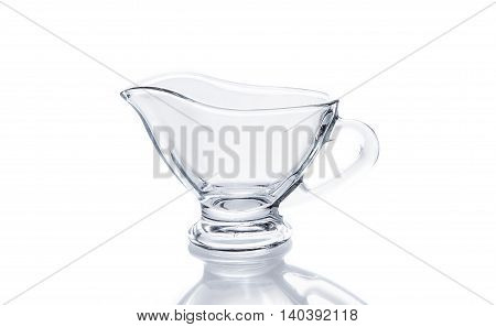 Glass sauceboat on white background with reflection