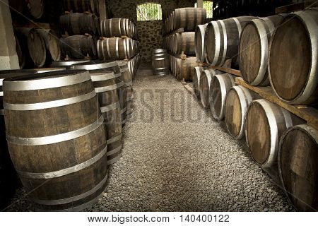 Wine barrels stacked in the old cellar of the winery.