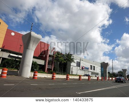 HONOLULU - NOVEMBER 29: HART Light Rail concrete guideway under construction in road center near a 24 Hour Fitness in Pearl City on Oahu Hawaii on November 29 2015. HART is building a 8 billlion dollar railway linking Oahu communities.