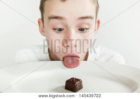Boy Sticks His Tongue Over Rim Of Plate