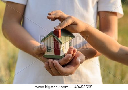 House toy on childs hands. outside photo