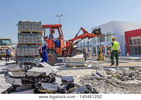 Zrenjanin Vojvodina Serbia - September 14 2015: Workers are helping forklift to place on right place plate compactor machine.