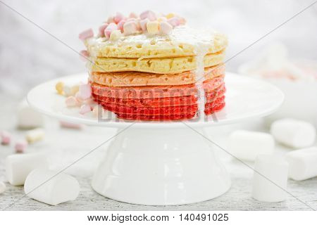 Ombre pancakes with marshmallow sauceon white background. Romantic breakfast for sunday morning selective focus