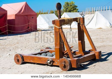 ancient Roman catapult with cannonballs in a military camp