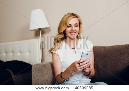 Positive smiling blond girl with mobile phone
