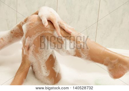 Young women washing her legs. Concept of care of body.