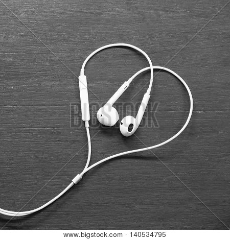 Headphone heart. Concept for valantine's day. White smalltalk on wood table.