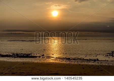 Sunset in Bali with fishermen in the distance
