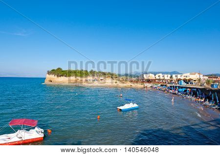 Sidary sandy beach people sunbath on the shore. Corfu Greece.