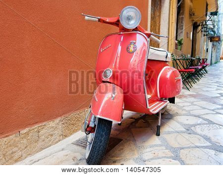 CORFU-AUGUST 22: Classic Vespa scooter on Kerkyra street on August 22 2014 on Corfu island. Greece. Vespa is an Italian brand of scooter manufactured by Piaggio.