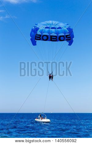 HURGHADA EGYPT - MAY 20: Parasailing in a blue sky near sea beach at May 20 2015 in Hurghada Egypt. Parasailing is a popular recreational activity among tourists in Egypt.