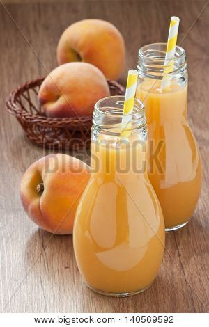 Fresh peach juice delicious summer drink and ripe peach fruit on wooden background