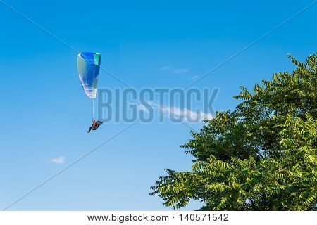 Paragliding in the sky. Man flying a paraglider on the sun.