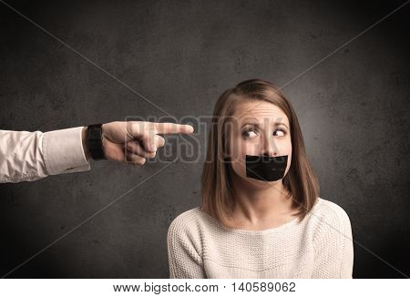 Caucasian business hand pointing at female employee with grunge background