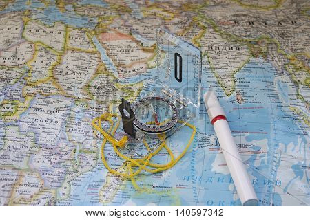 Сompass and a marker on a world map - tourism or traveling concept.