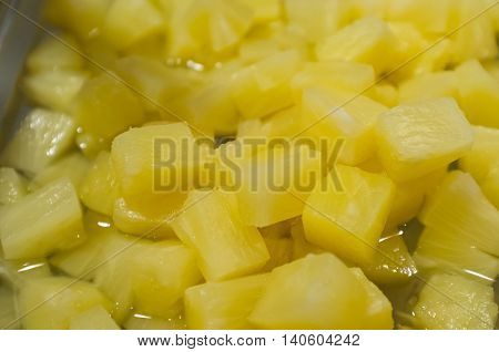 Diced chopped sweet pinapple closeup with juices background
