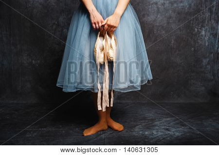 Ballerina Tying Ballet Shoes.Ballet dancer in blue skirt