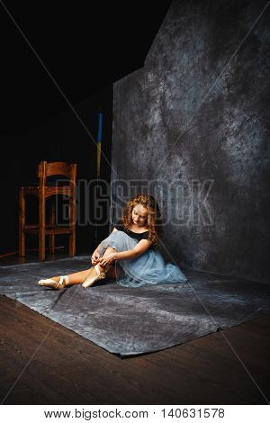 Ballerina Tying Ballet Shoes.Ballet dancer in blue skirt