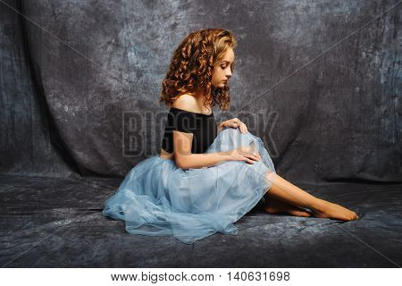 Ballerina Tying Ballet Shoes.Ballet dancer in blue skirt