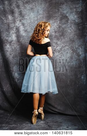 Ballerina Tying Ballet Shoes.Ballet dancer in blue skirt