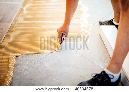 Industrial Worker Adding Glue On Cement Floor, Preparing Surface For Wood Parquet