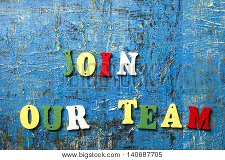 JOIN OUR TEAM CONCEPT. Wooden colorful abc letter abstract blue grunge background.