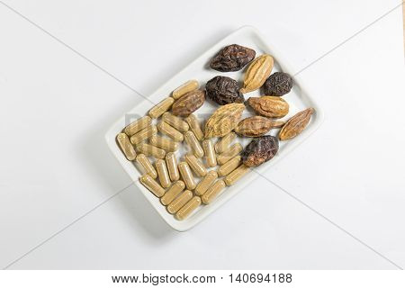 Herb with capsule and thai herb on white dish