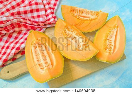 Four slices of cantaloupe melon on rustic table tasty summer refreshment selective focus