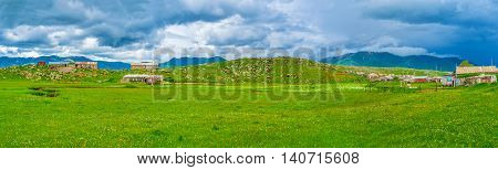 The mountain landscape of Kotayk Province in Armenia green meadow with dark mountains on the background.
