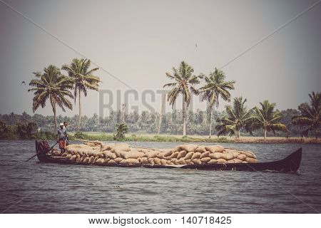 Allepey, Kerala, India March 31, 2015: Indian man transport dwell with rice for boats. backwaters canoe in state