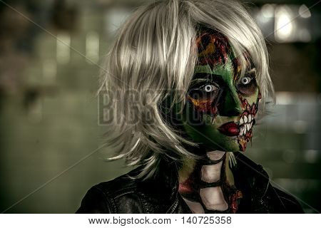 Terrible bloodthirsty zombie woman in the slums. Body-painting project. Glamorous zombie girl. Halloween make-up. Horror.