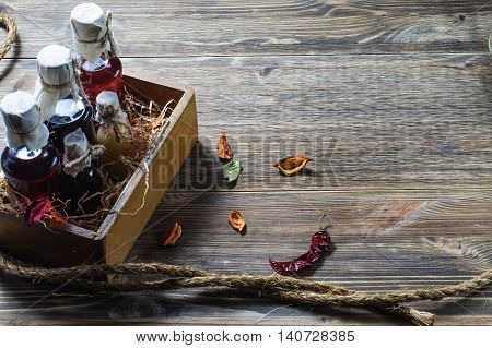 Small bottles of liquor in a wooden box on a wooden background. Small bottle with alcohol.
