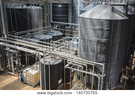 Row of stainless tanks in microbrewery. Modern interior.