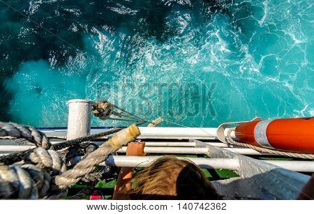 Starboard side of a ferry boat on the Adriatic Sea. The wake from a giant ship cruising through the blue ocean and clear skies.