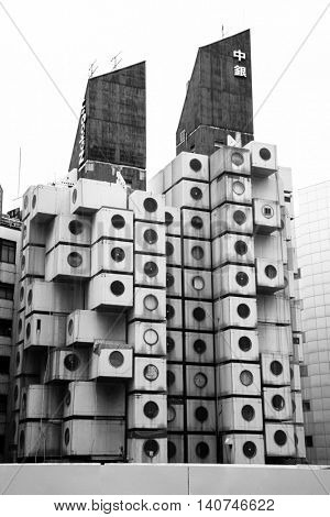 TOKYO, JAPAN - 22 JUNE 2016: The iconic Nakagin Capsule Tower in Shimbashi,Tokyo. Built in 1972  designed by Kisho Kurosawa and a rare surviving example of Japanese Metabolism style. Black and white.