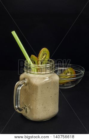 Smoothies bananas and kiwi with glass jar against a dark background