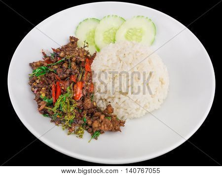 Rice topped with stir fried hot and spicy pork with basil isolated on the black background with clipping path