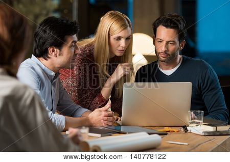 Colleagues working on a project until late. Dedicated employees working till late night preparing for a meeting. Business team working togheter for new proposal. 
