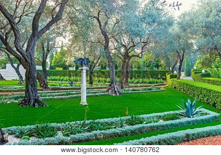 The small sculpture of the eagle waving his wings in shade of trees in Bahai Garden Haifa Israel.