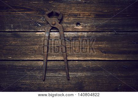 old rusty tongs on wooden boards background