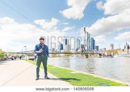Young Man Typing On Smart Phone In Frankfurt