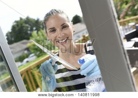 Homehelp cleaning house windows with squeegee