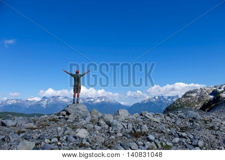 Man success pose on mountain top. Rainbow Mountain from Skywalk Trail near Whistler. Garibaldi Provincial Park British Columbia Canada.
