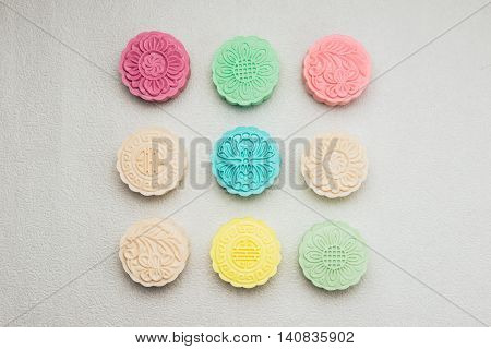 Traditional mooncakes on table. Chinese mid autumn festival foods. Sweet color of snow skin mooncake on plate.