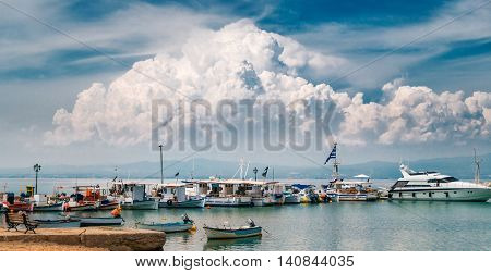 NEA-FOKEA GREECE - MAY 24 2015: Big cloud over boats yachts and Aegean sea. View from marina of Nea Fokia village Halkidiki Greece.
