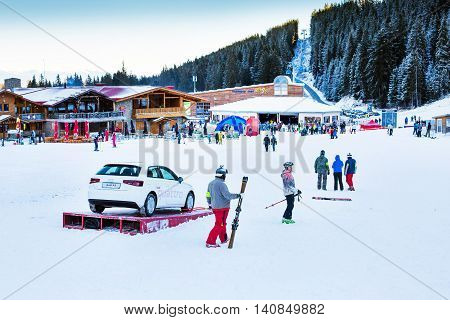 Bansko, Bulgaria - December, 12, 2015: Bunderishka polyana, restaurant, cafe, ski lift, mountains panorama with pine trees, people at Bansko ski resort