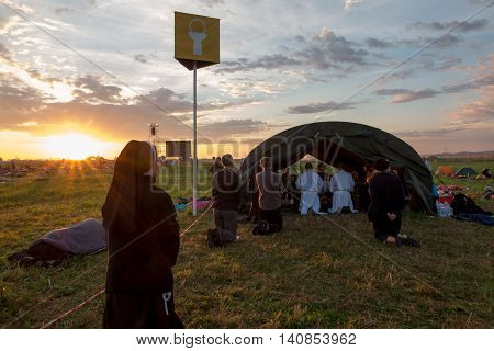 KRAKOW POLAND - JUL 31 2016 World Youth Day and the Catholic youth International Convention July 25-31. Adoration of the Eucharistic Jesus in the rear sectors of the youth on standby at sunrise.