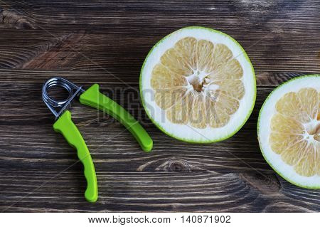 The concept of a healthy lifestyle. Pamela fruits and hand espander, flat lay.